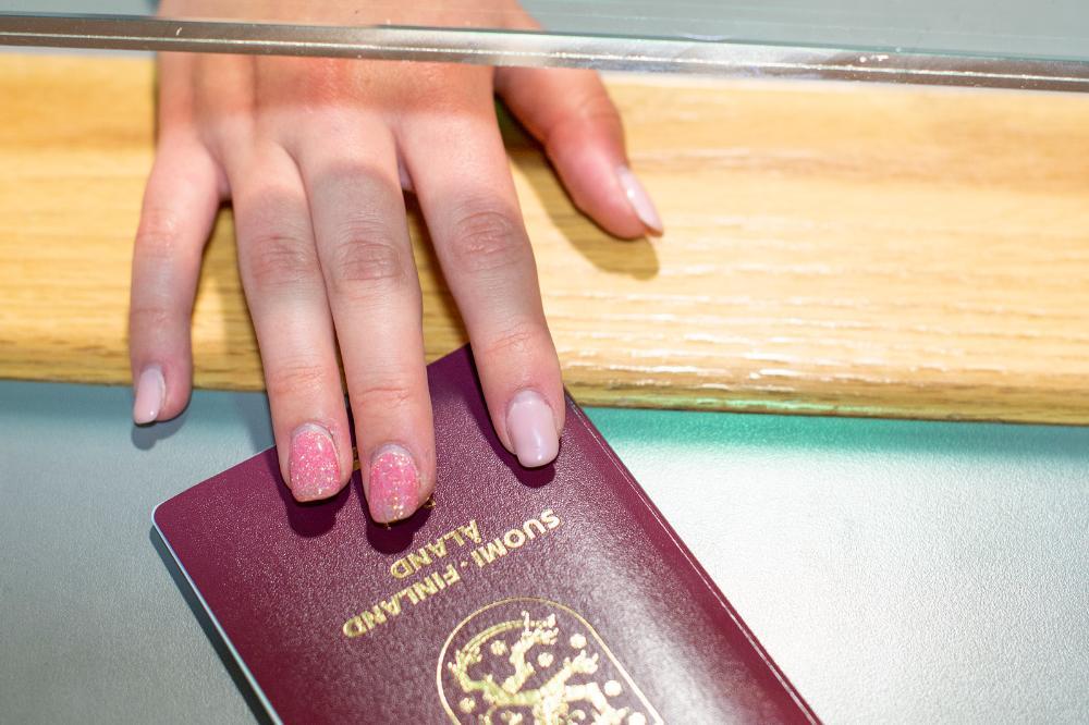 En hand överräcker ett finskt pass 